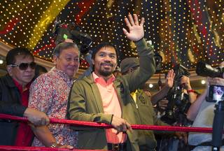 Boxer and Filipino congressman Manny Pacquiao waves to fans as he arrives at the MGM Grand Tuesday, June 5, 2012. Pacquiao will defend his WBO welterweight title against undefeated boxer Timothy Bradley Jr. at the MGM Grand Garden Arena Saturday.