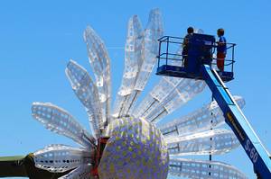 Workers put the finishing touches on a giant daisy for the Electric Daisy Carnival Thursday, June 7, 2012 at the Las Vegas Motor Speedway.