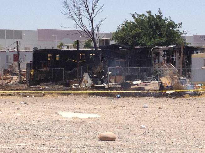 Charred hulls of two mobile homes can be seen from Las Vegas Boulevard North, where a morning fire Friday, June 15, 2012, killed three children, all under the age of 3.