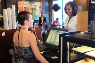 First lady Michelle Obama orders an iced tea from Ria Farmer at Sunrise Coffee Shop during a campaign stop in Henderson Tuesday, June 19, 2012.