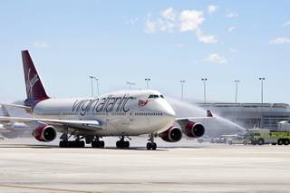 A Virgin Atlantic passenger jet, the first plane to arrive at Terminal 3, is welcomed with a water cannon salute during the opening day of the new terminal at McCarran International Airport Wednesday, June 27, 2012.