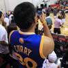 A Golden State Warriors fan takes a photo of his team before their NBA Summer League game Friday, July 13, 2012.