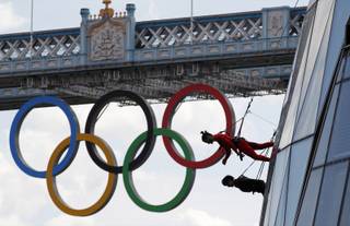 Backdropped by Tower Bridge, dancers perform hanging from outside the City Hall in London as part of London 2012 Olympic Festival, Sunday, July 15, 2012. (AP Photo/Sang Tan)