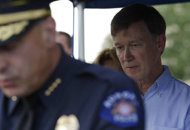 Colorado Gov. John Hickenlooper, right, listens as Aurora Police Chief Dan Oates, left, talks to reporters, Friday, July 20, 2012, during a briefing at Aurora City Hall in Aurora, Colo., not far from the movie theater where a gunman killed at least 12 people and wounded dozens of others.