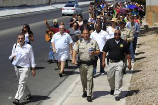 A group of Metro officers and congregants from various Christian churches march down Karen Avenue on a prayer walk Saturday, July 21, 2012.