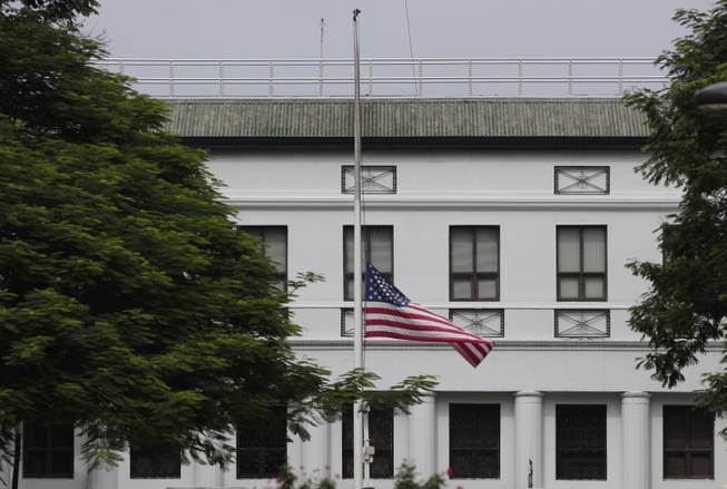 The U.S. flag flies half-mast at the U.S. Embassy in Manila, Philippines on Sunday July 22, 2012. U.S. President Barack Obama ordered that flags be flown at half-staff on federal buildings in honor of those killed in the shooting rampage at a Colorado movie theater.