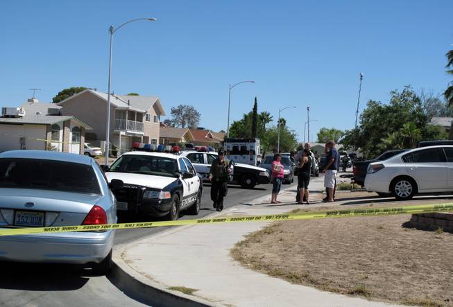 Metro Police cars swarm a western valley house in the aftermath of a shooting Friday, July 27, 2012. The shooting in a home in the 300 block of Altamira Road claimed the life of a woman and left a man in stable condition at University Medical Center.