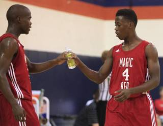 Marcus Allen hands his brother Malcolm Allen a drink at the Fab 48 tournament Friday, July 27, 2012, at Bishop Gorman.