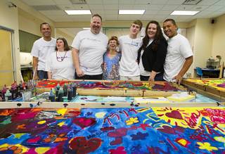 Volunteers from the Cosmopolitan pose with Opportunity clients after hand painting silk scarfs at the Opportunity Village Engelstad Campus on South Buffalo Drive Monday, July 29, 2012. From left are: Doug Filter, client Clarissa, Jeff Lalley, client Amanda, Nathan Wehner, Katie Gorski and Lorenzo Vierra. Corporate volunteers come to the campus once a month to work with clients, said art mentor Tim Ortiz.