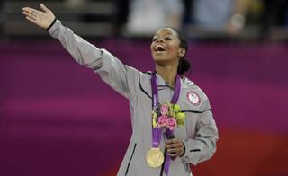 U.S. gymnast Gabrielle Douglas acknowledges the crowd after receiving her gold medal during the artistic gymnastics women's individual all-around competition at the 2012 Summer Olympics, Thursday, Aug. 2, 2012, in London. 