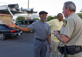 Mujahid Ramadan, left, talks with Metro Police Capt. Larry Burns at the Desert Gardens Condominiums complex near Martin Luther King Jr. Boulevard and Bonanza Road Monday, Aug. 6, 2012. Pastor Willie Cherry is in the background.