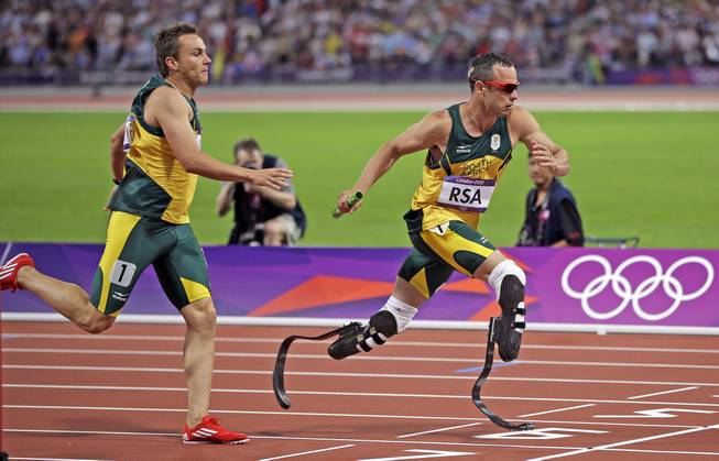 South Africa's Oscar Pistorius takes the baton from teammate L.J. van Zyl during the men's 4x400-meter in Olympic Stadium at the 2012 Summer Olympics, London, Aug. 10, 2012. 