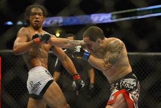 Benson Henderson from Arizona, left takes a right to the chin from Frankie Edgar from New Jersey in their middleweight title bout during UFC 150 in Denver, Saturday, Aug. 11, 2012. Henderson won the bout.