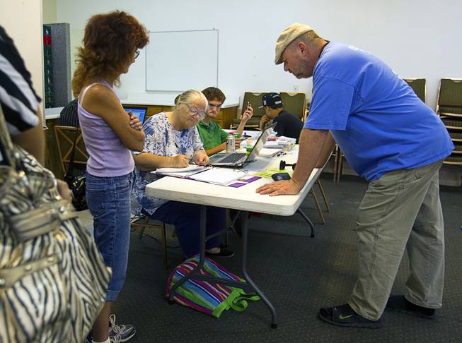 Vince Grandshold, right, signs up for food assistance at Sunrise Baptist Church, 1780 Betty Lane, Thursday, Aug. 23, 2012. Grandshold recently lost his job but is not yet receiving unemployment benefits, he said.