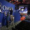 Workers place Romney-Ryan campaign sign inside of the Tampa Bay Times Forum at the Republican National Convention in Tampa, Fla., on Sunday, Aug. 26, 2012, as pictures of astronaut Neil Armstrong, who died the previous day, are displayed on the main stage.
