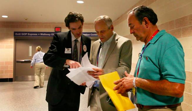 Nevada delegation chair Wayne Terhune discusses a petition to enter Ron Paul's name on the ballot with delegates in the hallway off the convention floor Tuesday afternoon, Aug. 28, 2012.