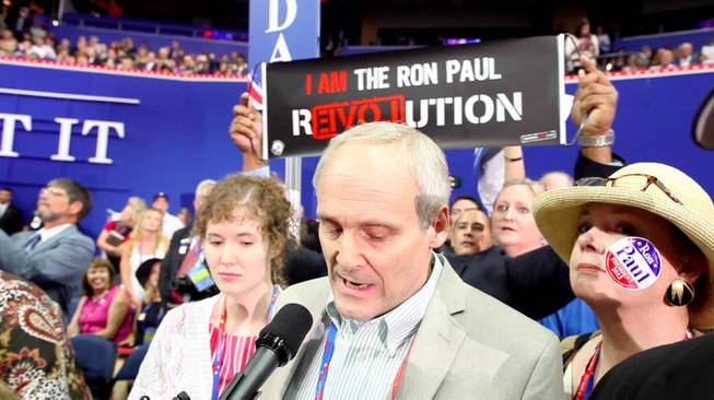 Nevada delegation chair Wayne Terhune announces the Nevada delegates' vote for Ron Paul on the floor of the RNC Tuesday evening, as members of the delegation display Ron Paul emblems and paraphernalia they snuck into the convention hall, Aug. 28, 2012.
