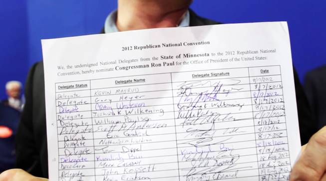 A delegate from Minnesota holds his state's copy of the petition to officially nominate Ron Paul for a vote, Tuesday, Aug. 28, 2012.