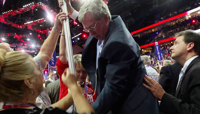 Former Nevada Governor Bob List yanks the Nevada signpost pole out of the floor after the Republican National Convention Thursday night Aug. 30, 2012, with an assist from Nevada delegate Kim Bacchus, National Committeewoman Heidi Smith and Washoe County GOP chairman Dave Buell, as Lieutenant Brian Krolicki (right) spots List's standing on a folding chair.