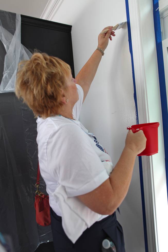 Elizabeth Foyt, an alternate delegate, paints a wall in the modular home Nevada volunteers and others worked on Monday morning.