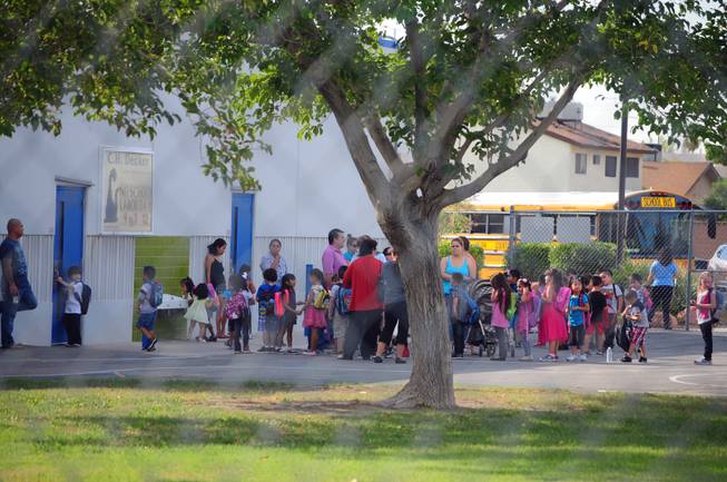 Elementary school students wait on the blacktop at Decker Elementary School on Wednesday, Sept. 5, 2012. About 700 Diskin Elementary School students went to Decker on Wednesday after the 39-year-old school's air-conditioning system failed on Tuesday.