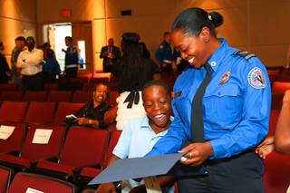 Diamate Johnson, 9, joyfully reacts when his mom, Aja Johnson, shows him her Transportation Security Administration (TSA) homeland security certificate she received during a TSA graduation ceremony Wednesday, Sept. 12, 2012, at the College of Southern Nevada Charleston campus in Las Vegas.