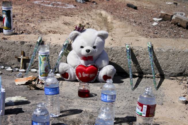 Open water bottles are seen along with other mementoes at the memorial site of the bus stop crash Friday, Sept. 14, 2012.