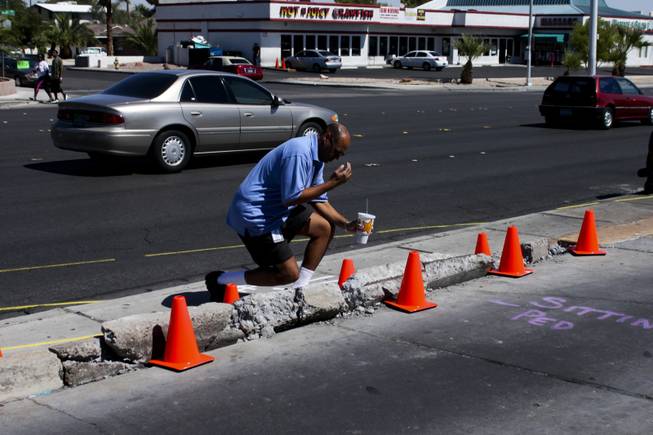 Deacon Andre Richard from the Roman Catholic Diocese of Las Vegas says a prayer at the memorial site of the bus stop crash, Friday, Sept. 14, 2012.