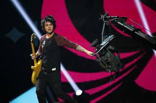 Green Day lead vocalist and guitarist Billie Joe Armstrong grabs a camera during the 2012 iHeartRadio Music Festival at MGM Grand Garden Arena on Friday, Sept. 21, 2012.
