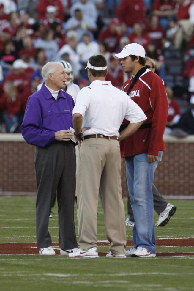Kansas State head coach Bill Snyder, left, talks with Oklahoma head coach Bob Stoops, center, and quarterback Sam Bradford, right, before an NCAA football game in Norman, Okla. on Saturday, Oct. 31 2009.
