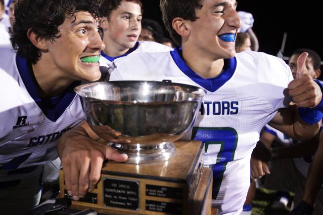 Green Valley players Kyler Chavez, left, and Christian Lopez pose with the Henderson Bowl trophy after beating Basic 31-27 during the Henderson Bowl at Basic High School in Henderson on Friday, September 28, 2012.