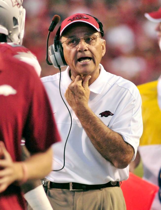 Arkansas coach John L. Smith talks to a player on the sidelines during the first half of an NCAA college football game against Rutgers in Fayetteville, Ark., Saturday, Sept. 22, 2012.