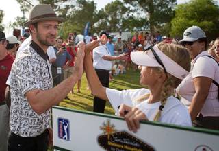 Justin Timberlake gives a high-five to standard bearer Annick Haczkiewicz, 12, during the Pro-Am portion of the Justin Timberlake Shriners Hospitals for Children Open at TPC Summerlin Wednesday, Oct. 3 2012.