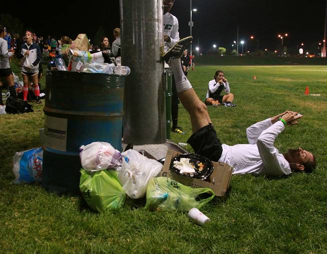 Next to the detritus of the day, OSC player Ben Kozy from Washington D.C. puts his legs up while listening to music before their championship game during the World Adult Kickball Association Founders Cup Saturday, Oct. 6, 2012.