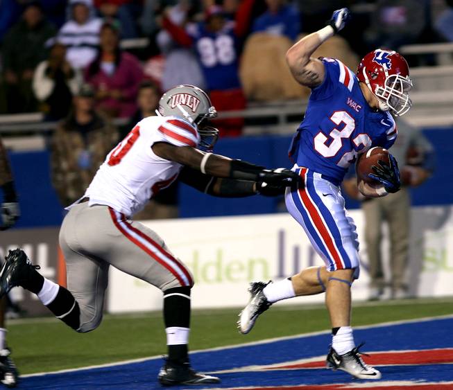 Louisiana Tech's Ray Holley (32) scores a touchdown ahead of UNLV defender Princeton Jackson during their NCAA college football game, Saturday, Oct. 6, 2012, in Ruston, La.