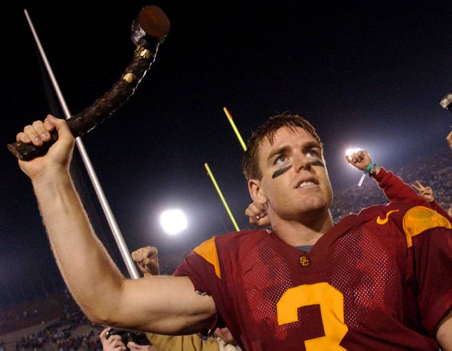 In this Nov. 30, 2002, AP file photo, Southern California quarterback Carson Palmer holds up the Jeweled Shillelagh to celebrate USC's 44-13 win against Notre Dame in an NCAA college football game in Los Angeles. For each USC victory a Trojan head with a ruby is attached and for each Irish victory, an emerald-studded shamrock is attached  — making it one expensive club. 