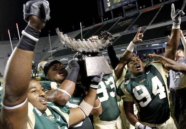 UAB linebacker Jestin Williams (56), and teammates Greg Calhoun (64), Andrew Mahan (93), and Bryant Turner (94) celebrate holding the Bones trophy after beating Memphis 31-15 during the second half of an NCAA college football game on Saturday, Nov. 20, 2010, in Birmingham, Ala. 