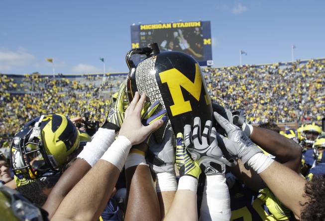 Michigan football players hold the Little Brown Jug after defeating Minnesota 58-0 during a college football game in Ann Arbor, Mich., Saturday, Oct. 1, 2011. Michigan kept the jug, the oldest trophy game in major college football that dates to 1909. 