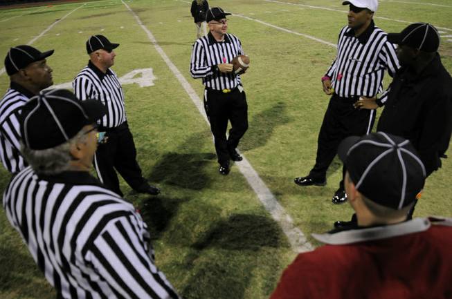 The officiating crew for the game between the visiting Gators and the Wildcats have a pre-game huddle at mid-field on Friday night at Las Vegas High School.