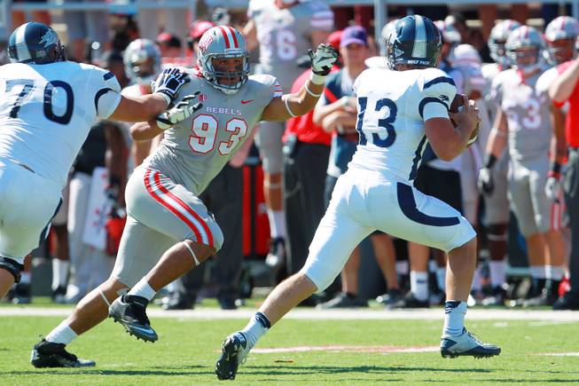 UNLV defensive lineman Sonny Sanitoa chases UNR quarterback Devin Combs out of the pocket during their game Saturday, Oct. 13, 2012 at Sam Boyd Stadium. UNR came from behind and won the game, for the eighth consecutive time, 42-37.
