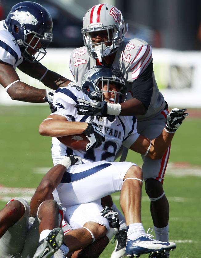 UNLV defensive back Fred Wilson helps stop UNR wide receiver Richy Turner during their game Saturday, Oct. 13, 2012 at Sam Boyd Stadium. UNR came from behind and won the game, for the eighth consecutive time, 42-37.