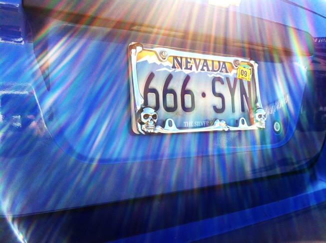 Glare from sunlight frames this provocative license plate.