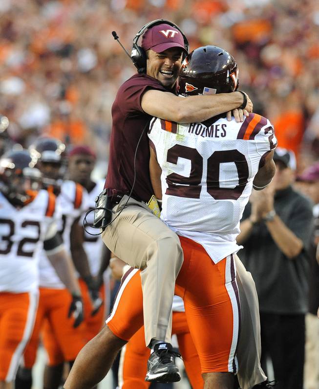 Virginia Tech assistant coach Shane Beamer leaps into the arms of his running back Michael Holmes after Holmes scored a touchdown to give Virginia Tech a 17-13 lead over Cincinnati during an NCAA college football game, Saturday, Sept. 29, 2012, in Landover, Md. Cincinnati defeated Virginia Tech 27-24. 