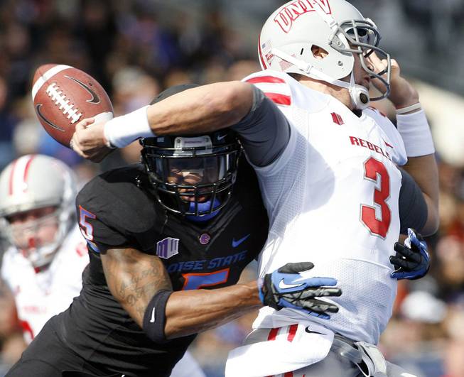 Boise State's Jamar Taylor hits UNLV quarterback Nick Sherry, causing Sherry to lose the ball Saturday, Oct. 20, 2012, in Boise, Idaho.