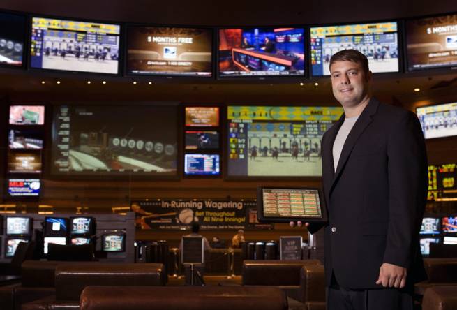 Race and sports book director Mike Colbert poses with a wireless tablet at the M Resort on Wednesday, Aug. 4, 2010. Customers with accounts can use the tablet to place bets without standing in line. The sports book also has 