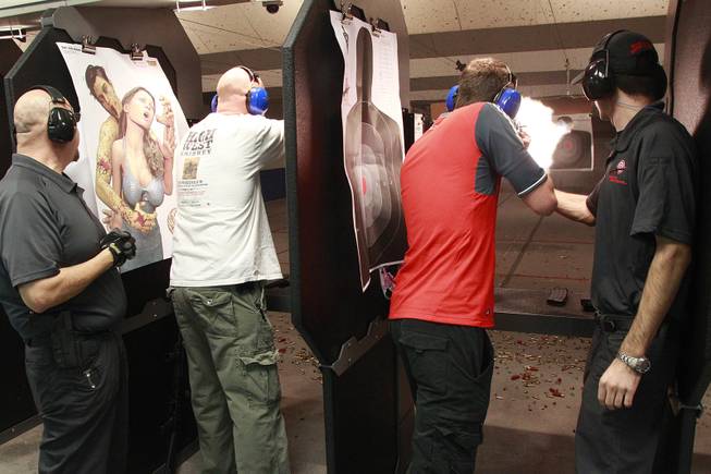Jason Smith, left, and Matthew Cook fire guns at the Guns and Ammo Garage Oct. 25, 2012.