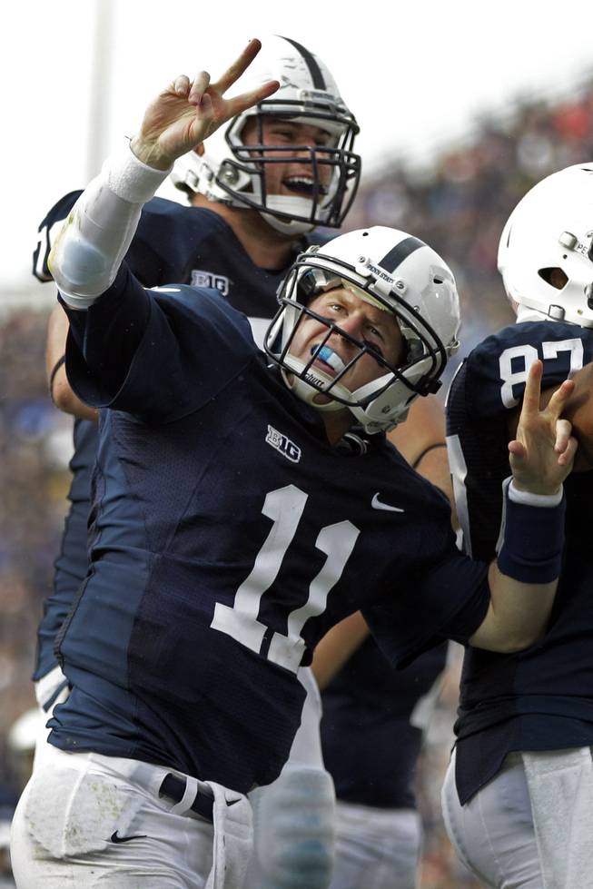 Penn State quarterback Matthew McGloin (11) and Penn State offensive tackle Mike Farrell, rear, celebrate McGloin's rushing touchdown during the second quarter of an NCAA college football game against Temple in State College, Pa., Saturday, Sept. 22, 2012.