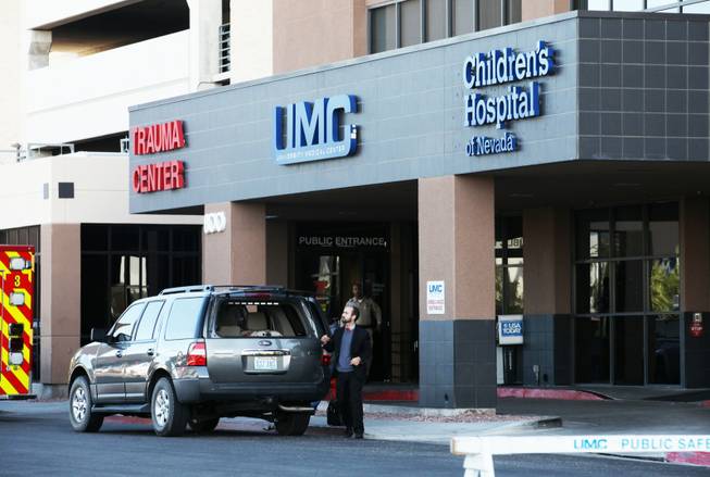 A Reid staffer goes to retrieves a suit jacket and rolling briefcase from the back of an SUV outside the Trauma Center at University Medical Center Friday, Oct. 26, 2012.