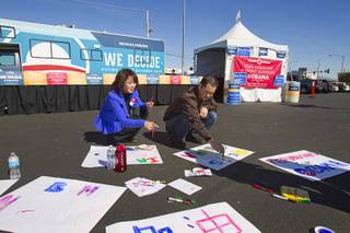 Masako and Isao Kimura work on signs before an Asian American and Pacific Islander early voting rally for President Obama at the Chinatown Mall on Saturday, Oct. 27, 2012.