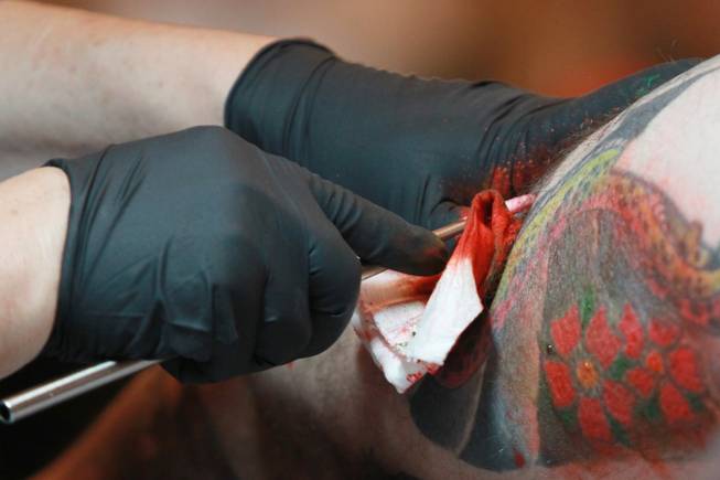 Artist Horitoshi 1 uses a traditional Japanese tattooing technique called Tebori at Mario Barth's Biggest Tattoo Show on Earth at the Mirage on Saturday, Oct. 27, 2012. (The red is excess ink, not blood.)